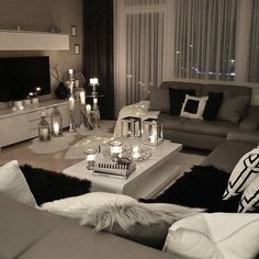 a living room filled with lots of furniture and candles on top of the coffee table