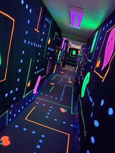 the hallway is lit up with neon lights and black walls that are covered in dots