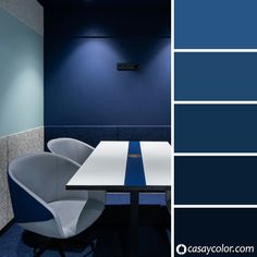 an office with blue walls and white chairs in front of a table that is next to the wall