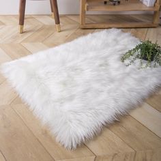 a white sheepskin rug sitting on top of a wooden floor next to a chair