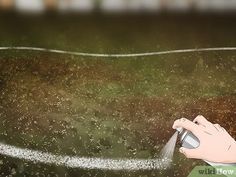 someone is spraying water on the ground with their hand and holding an object in front of them