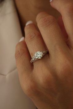 a woman's hand with a diamond ring on it