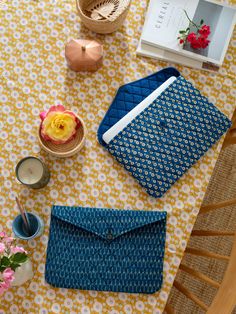 a table topped with blue and yellow items on top of a white table covered in flowers