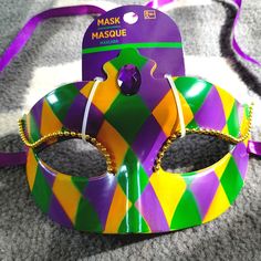 New In Original Package," Mardi Gras Style," Features Molded, Hard Plastic With A Diamond Shape Pattern In Vibrant Colors, Purple, Yellow And Green, Gold Trim Framing Accentuating The Eyes, A Center Faceted Acrylic, Purple Bead, Purple Ribbon Tie Closure. 972050214 Multicolor Masquerade Mask For Halloween Party, Multicolor Masks For Mardi Gras Costume Party, Fun Carnival Party Masks, Multicolor Masks For Halloween Party, Multicolor Party Masks For Halloween, Multicolor Masks For Carnival Party, Fun Party Masks For Carnival, Multicolor Halloween Party Masks, Multicolor Carnival Party Masks