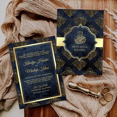 the wedding stationery is set up on top of a wooden table next to a pair of scissors