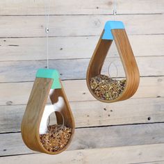 two wooden bird feeders hanging from strings