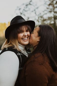 two women are kissing each other outside