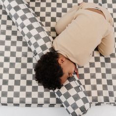 a woman laying on top of a checkered blanket