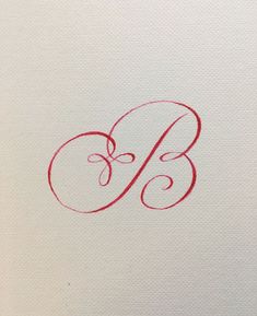 the letter b is drawn in red ink on white paper with a black pen next to it