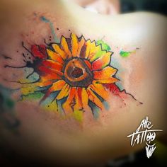 an artistic sunflower tattoo on the back of a woman's shoulder and chest