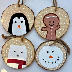 four wooden ornaments with snowmen, penguins and gingerbreads hanging from twine