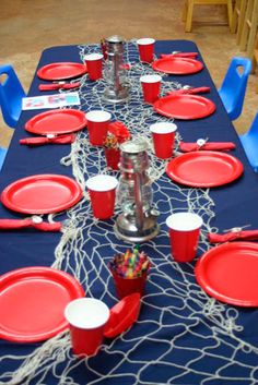 the table is set with red cups and plates