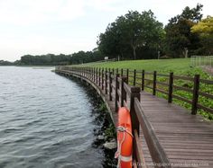 an orange buoy sitting on the side of a wooden pier next to a body of water