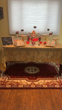 the table is set up for an event with desserts on it and decorations at the top