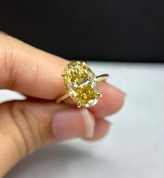 a person holding a yellow diamond in their hand