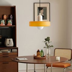 a dining room table with two chairs and a potted plant