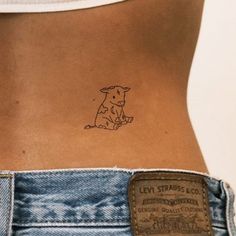 a small dog tattoo on the back of a woman's stomach