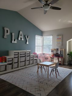 a playroom with toys and storage bins on the floor