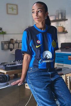 a woman sitting on top of a table next to a record player's turntable