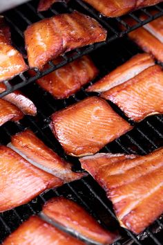 several pieces of salmon cooking on a grill