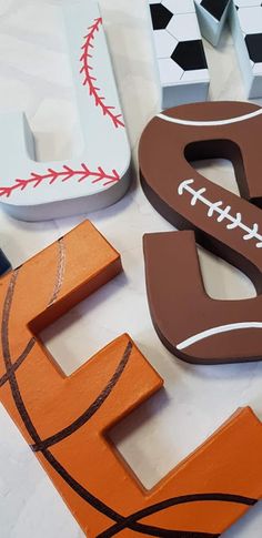 the letters are made out of wood and decorated with baseballs, basketballs, and numbers