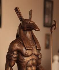 a wooden statue of a rabbit holding a staff