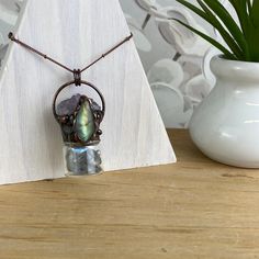 Fun and trendy Bohemian Style Gemstone Bottle Necklace with an accent stone is a unique and stylish piece of jewelry that combines the beauty of gemstones with a bohemian-inspired design. The necklace features a small bottle-shaped pendant, often made of glass, that is filled with natural gemstones of Amethyst, Labradorite, Jasper or Tiger's Eye. The accent stone is a larger and more striking stone that is set in a prominent position on the necklace, such as the top of the bottle pendant. Bohemi Bohemian Handmade Moonstone Necklace, Nature-inspired Healing Necklace With Raw Stone, Bohemian Raw Stone Pendant Jewelry, Bohemian Jewelry With Gemstone Accents, Adjustable Bohemian Labradorite Necklaces, Adjustable Gemstone Amulet Jewelry, Silver Meditation Jewelry With Raw Stone, Bohemian Moonstone Jewelry With Gemstone Accents, Adjustable Mystical Pendant Jewelry