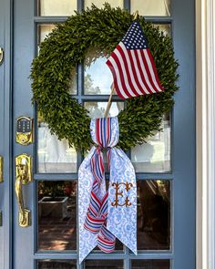 a wreath with an american flag hanging on the front door