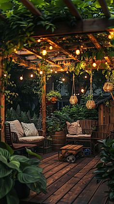 an outdoor seating area with hanging lights and potted plants on the deck, surrounded by greenery