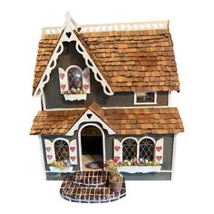 a doll house with flowers and hearts painted on the roof is shown in full view