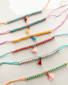 several different colored beads and tassels on a white surface