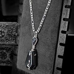 Our beautifully crafted Serpentine necklace features a unique coffin-shaped obsidian stone mounted within a serpent-accented setting, enhanced with a faceted teardrop gemstone for an extra touch of elegance. The black obsidian stone adds another element to this design with its naturally cleansing earthly elements. Paired with a figaro style chain, every aspect of this necklace emits graceful, bold, and uniquely dark vibes. A true gem for those that revere dark aesthetics.    Specifications: ✌️Ha Black Teardrop Necklace With Natural Stones, Black Teardrop Spiritual Necklace, Black Spiritual Teardrop Necklace, Spiritual Black Teardrop Necklace, Serpentine Necklace, Dark Vibes, Black Obsidian Stone, Dark Aesthetics, Obsidian Stone