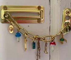 there is a gold chain attached to the door with keys and charms hanging from it