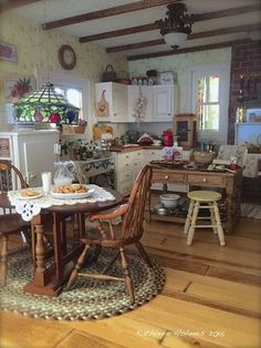 a kitchen filled with lots of wooden furniture and decor on top of a hard wood floor