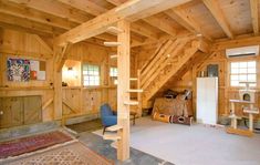 a loft with wooden walls and stairs leading to the upper floor, along with an area rug on the floor