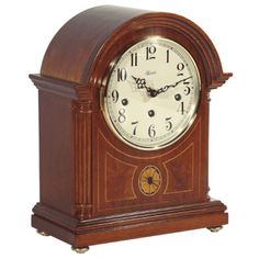 a wooden clock with roman numerals on the front and sides, sitting upright