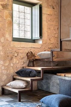 a room with stone walls and steps leading up to a window