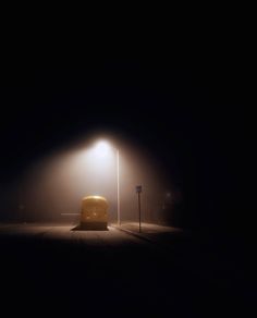 a bus parked on the side of a road under a street light in the dark