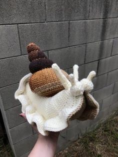 someone is holding up a knitted hat with two hats on it's head