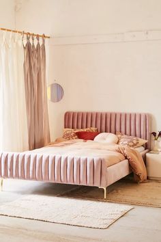 a bedroom with a bed, rug and curtains