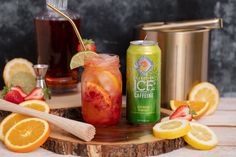 an iced drink with strawberries and lemons on a cutting board next to other drinks