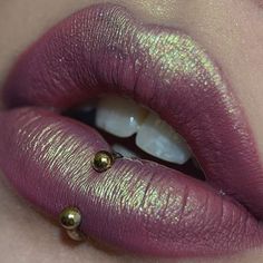 a woman's lips with gold and purple makeup