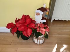 a potted plant with poinsettia and santa clause on it