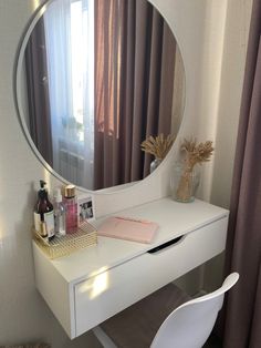 a white desk with a mirror on top of it and a chair next to it