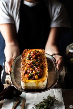 a person is holding a plate with food on it and some utensils nearby