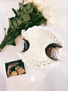 there is a cake with flowers on the table next to it and an old photo