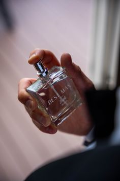 a person holding a small glass bottle in their hand with the word dior written on it