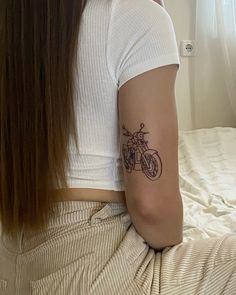 a woman with a motorcycle tattoo on her arm