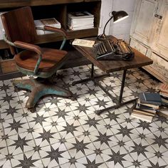 an old fashioned desk and chair in the corner of a room with books on it