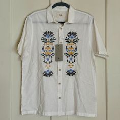 Folk Clothing Short Sleeve Button Up Shirt Condition: Excellent, New With Tags Color: White With Multicolored Embroidery Style: Mast Size: Medium Measurements: Chest (Armpit To Armpit): 22 Length: 28 In. Sleeve Length: 10 In. Details: Fabric Has A Soft And Has A Linen-Like Feel Collared Tops With Floral Embroidery For Vacation, White Summer Shirt With Buttons, White Shirt With Button Closure For Vacation, White Button Shirt For Summer, Embroidered Spread Collar Shirt For Summer, White Summer Shirt With Button Cuffs, White Short Sleeve Shirt With Button Cuffs, Casual Shirt With Floral Embroidery For Vacation, Floral Embroidered Collared Shirt For Vacation